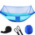 Two people sitting in a blue hammock with mosquito net in a forest setting